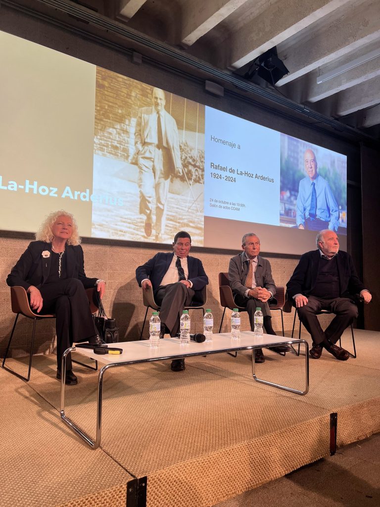 Mesa redonda del homenaje en el salón de actos del COAM, con la pantalla al fondo