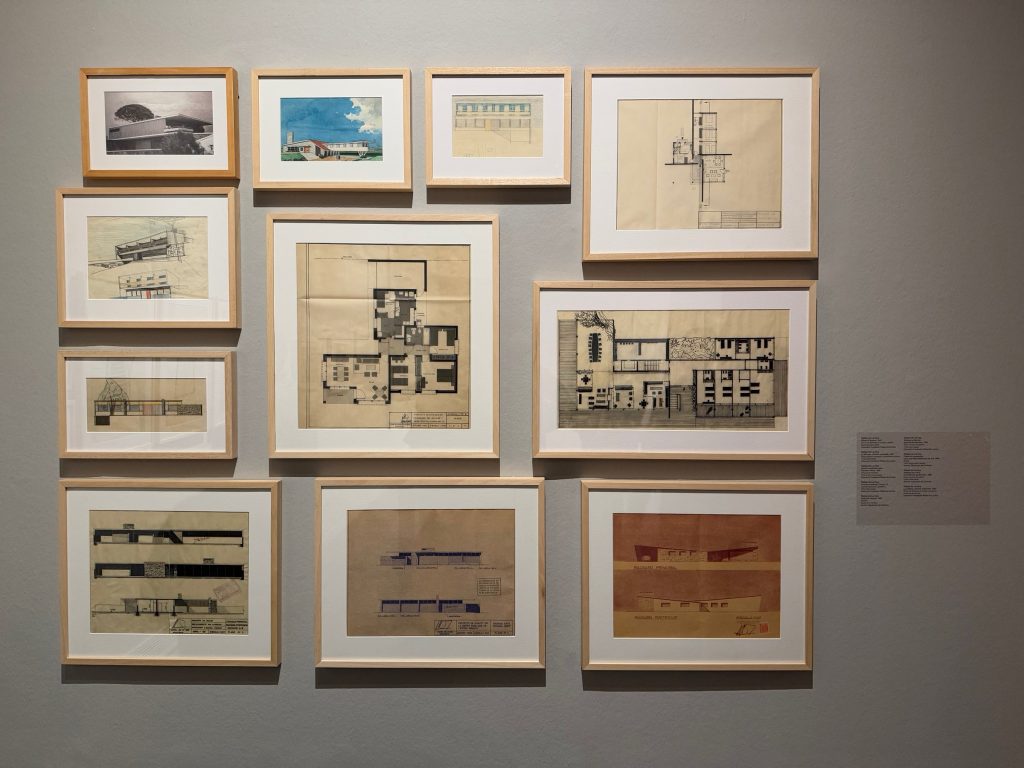 Pared con planos, dibujos y fotografías enmarcados