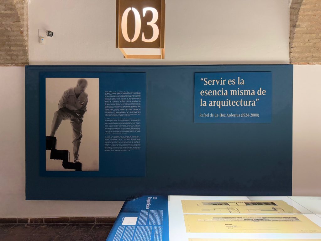 Panel con la cita «Servir es la esencia misma de la arquitectura» y un retrato del arquitecto subiendo una escalera