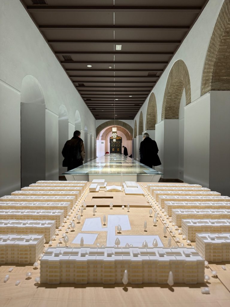 Maqueta de un conjunto de viviendas en primer término y la galería al fondo