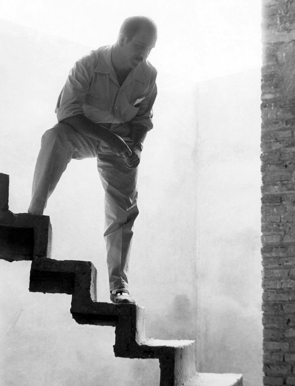 Rafael de La-Hoz Arderius, joven, bajando por una escalera de hormigón en voladizo, a contraluz.
