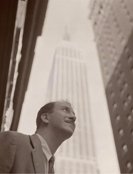 Rafael de La-Hoz Arderius, joven, mirando hacia arriba en una calle de Nueva York, con el Empire State al fondo.